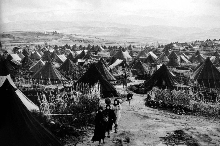 فلسطينيات يحملن أمتعتهن في مخيم نهر البارد للاجئين بالقرب من مدينة طرابلس الساحلية شمال لبنان عام 1952 (رويترز)